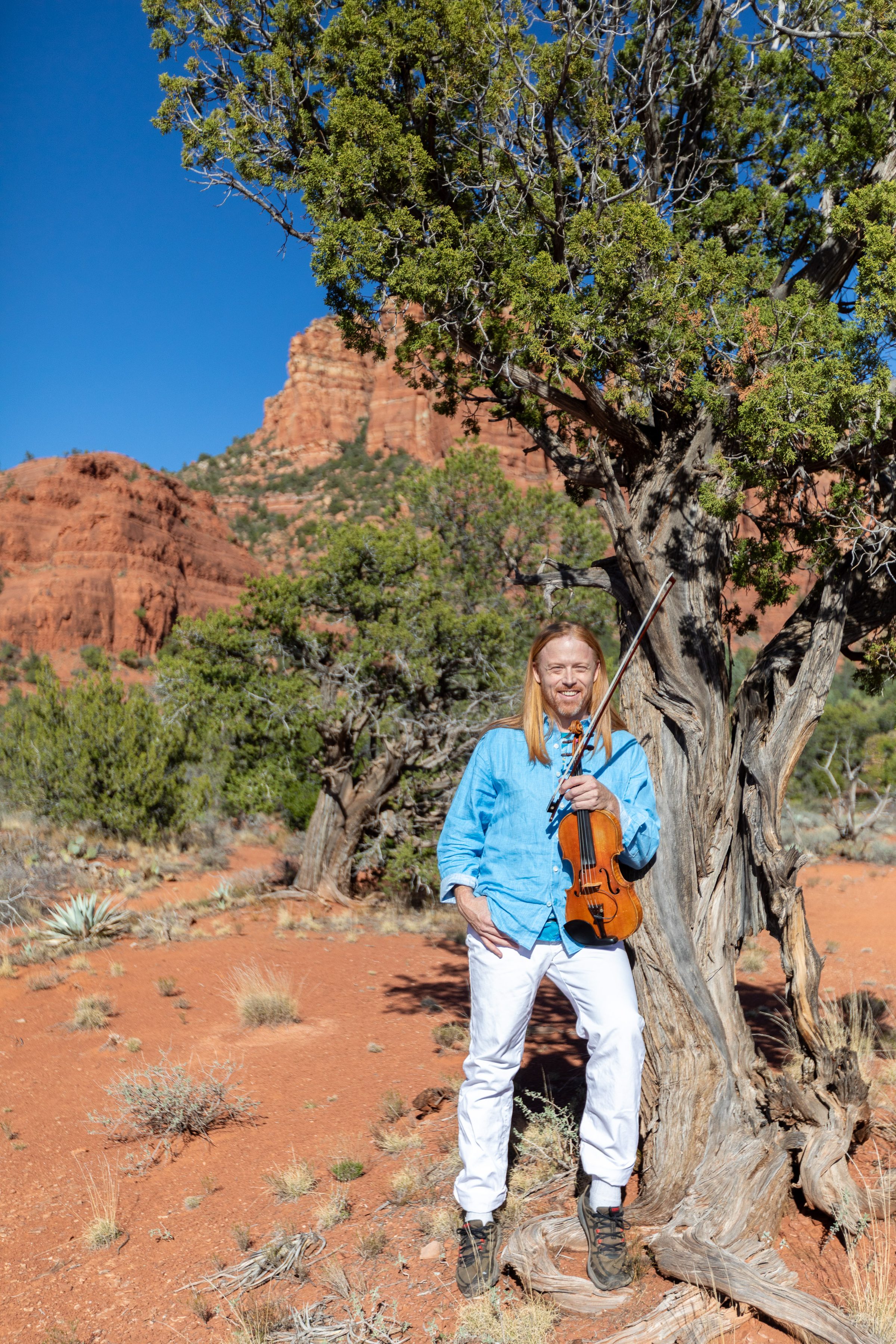 Tyler Carson with violin in Sedona red rock landscape